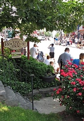 The Brickhouse Inn sign posted out front with a street lined with crowds during a festival